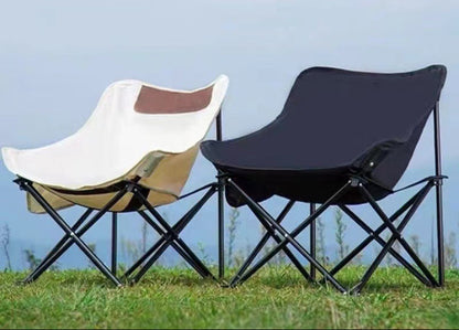 Two portable folding chairs on grass with a clear sky background
